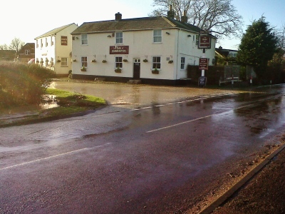 Flooded road by The Inn at Emmington, leading into Sydenham